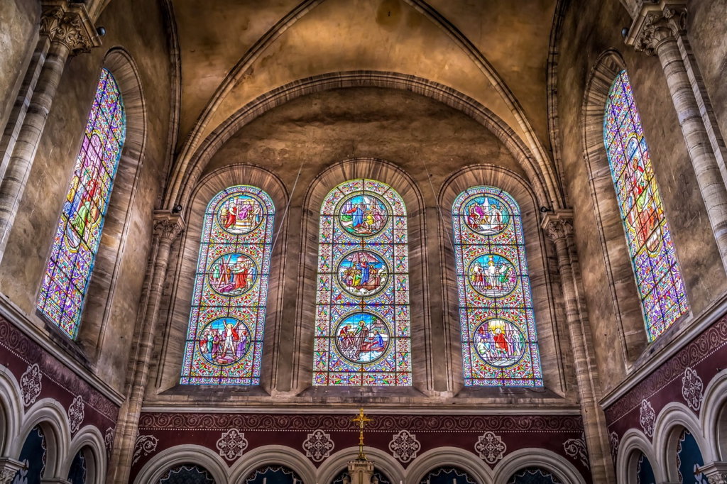 Three giant glass windows on the church wall 