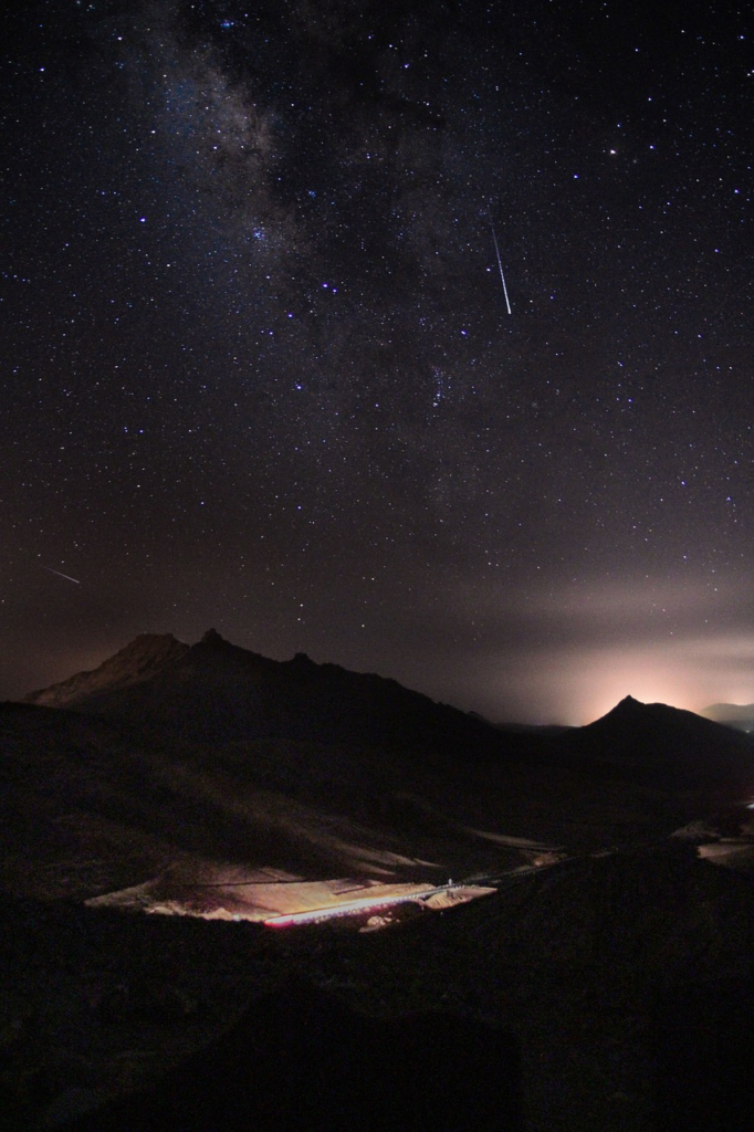 Night sky full of stars in a mountain range. 